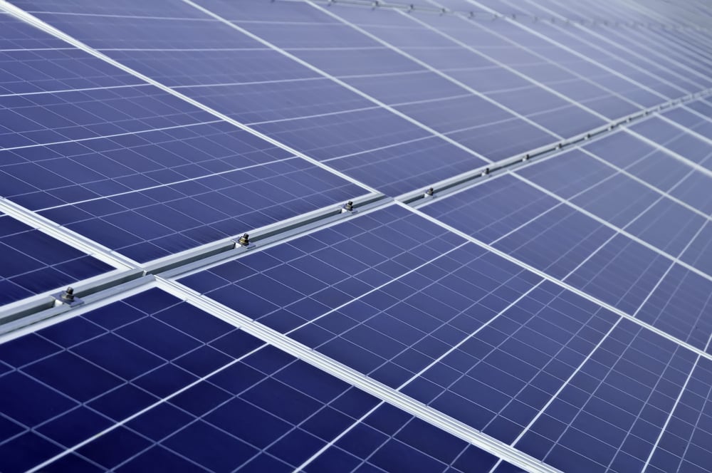 Long array of solar panels in bright sunlight